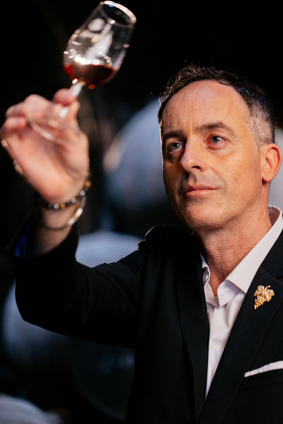 Retrato de Miguel Martins, sumiller, observando una copa de vino